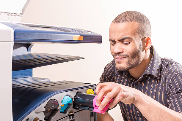 doubting african man fixing copier in the office